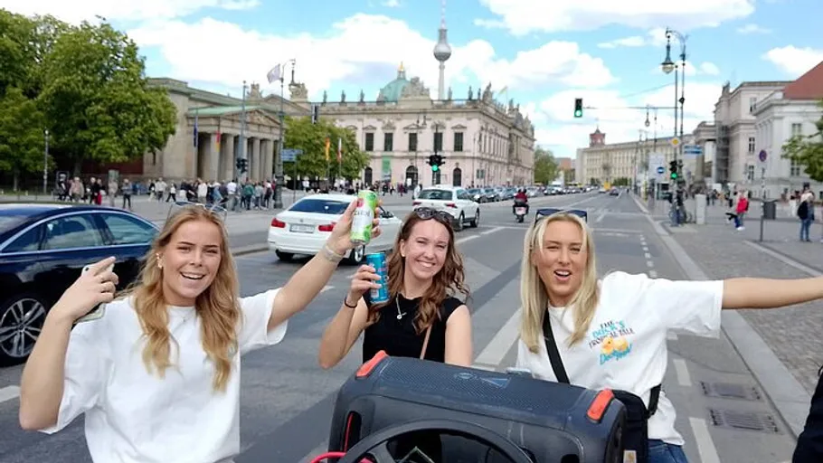 Three women celebrating on a busy urban street.