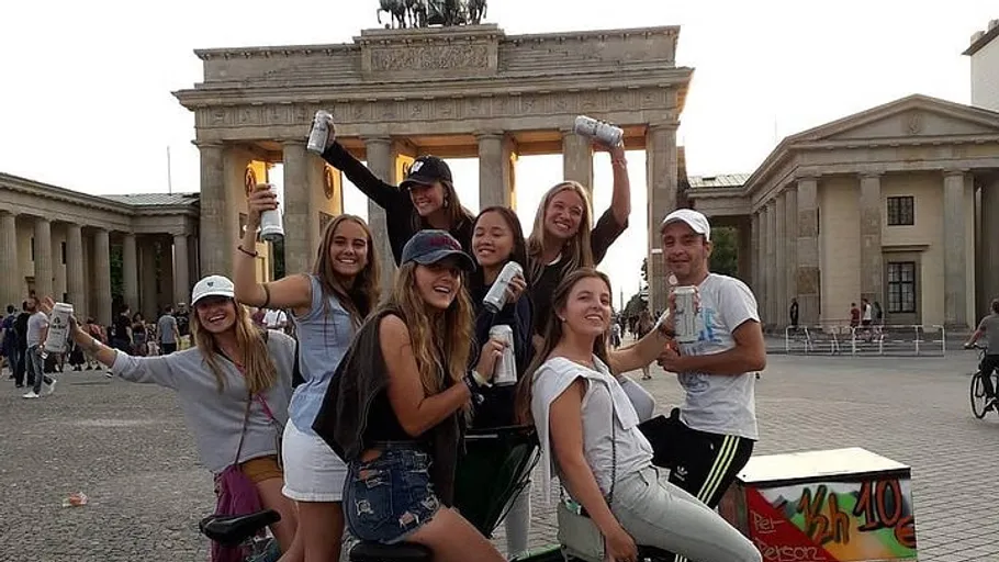Group of people smiling in front of Brandenburg Gate.