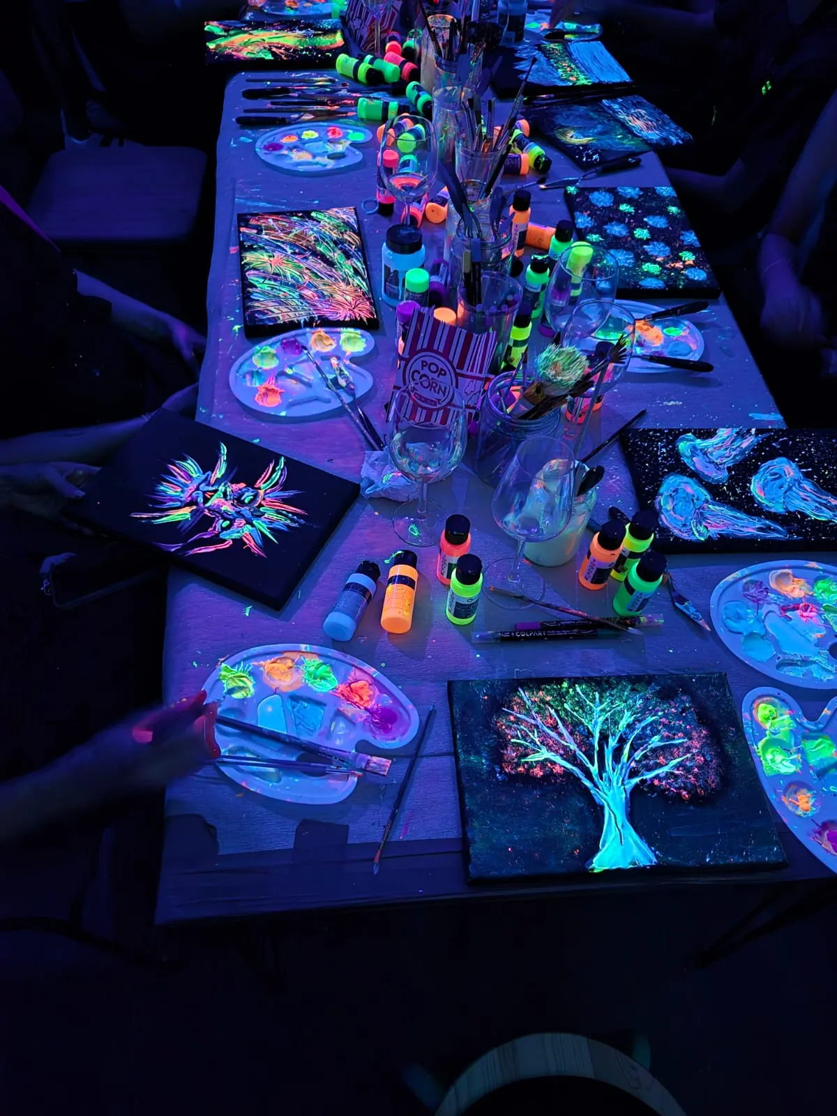 Leuchtende Kunstmaterialien und Gemälde auf Tisch.