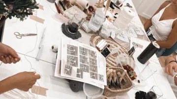 People crafting at a table with supplies.