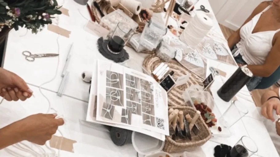 People crafting at a table with supplies.
