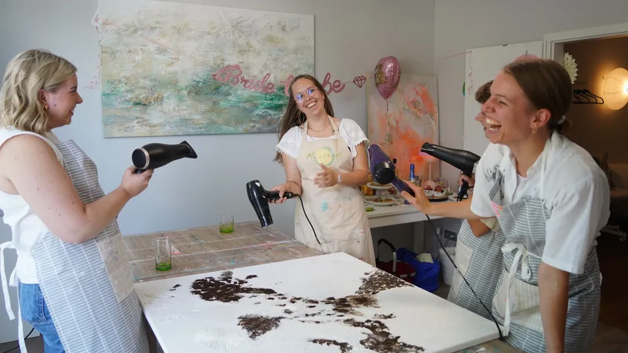 Frauen benutzen Föhne, um drinnen Kunst zu schaffen.