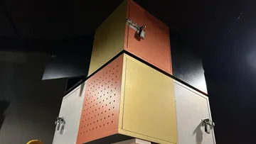Bunte Metallschränke gestapelt in einem dunklen Raum.