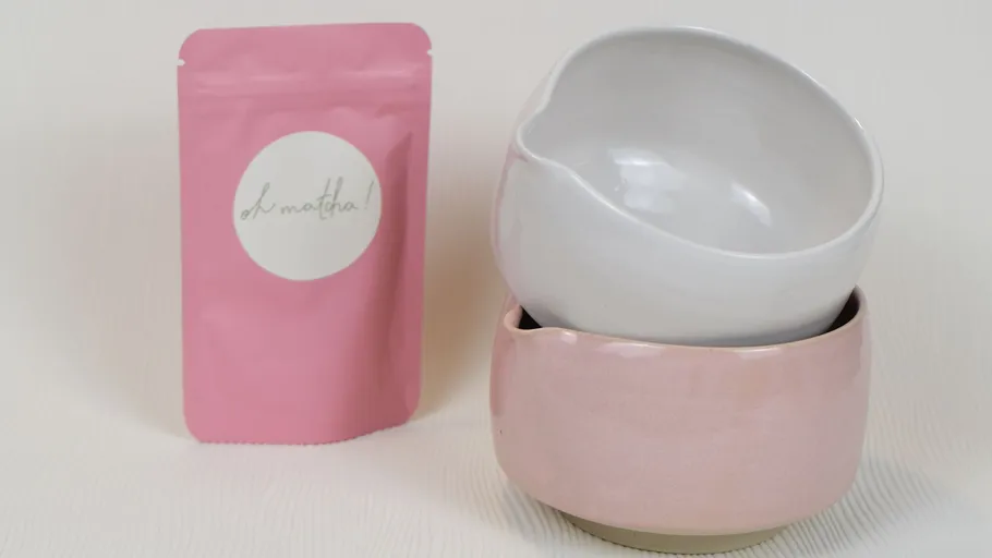 Pink pouch and two ceramic bowls stacked.