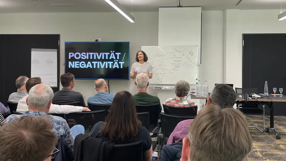 Frau präsentiert im Konferenzraum vor Teilnehmern.