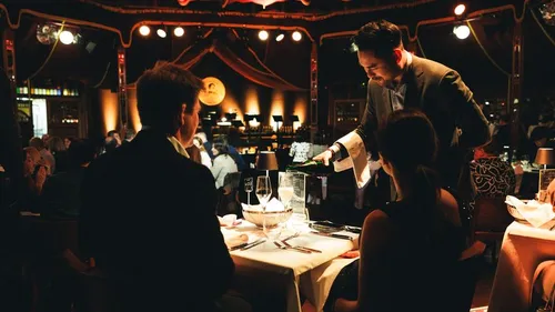 Kellner serviert Wein einem Paar im Restaurant.