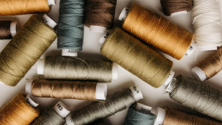 Colorful spools of thread scattered on surface.