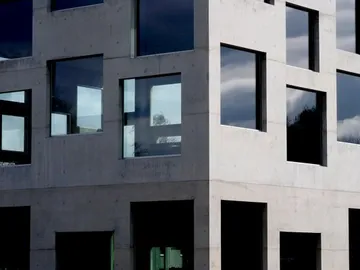 Betongebäude mit zahlreichen Fensteröffnungen, in hellem Licht.