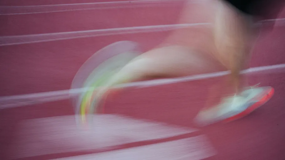 Blurry runner on a red track.