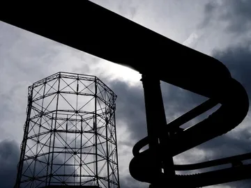 A tower and a tube are silhouetted in front of clouds.