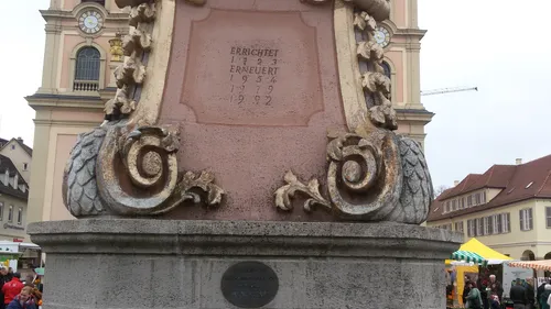 Steinsockel eines Denkmals mit eingraviertem Text.