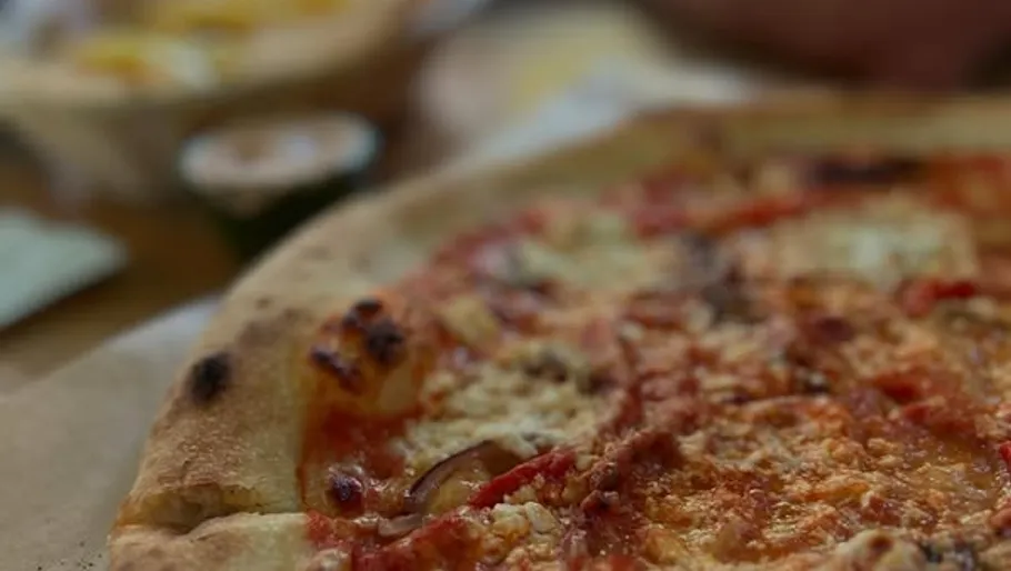 Nahaufnahme eines Käsestück einer Pizza.