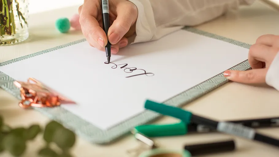 Handschrift auf Papier mit dekorativem Stift.