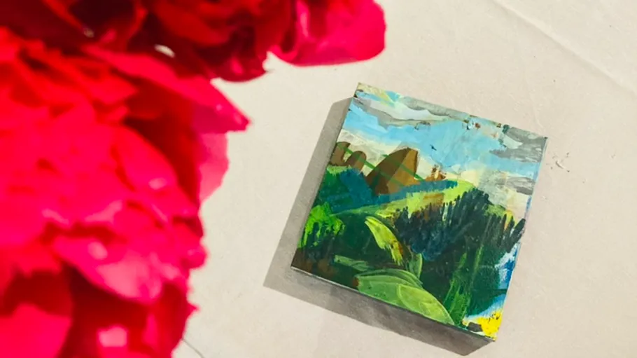 Painting of landscape near pink flowers.