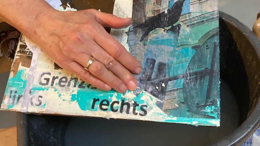 Hand smoothing paper over a bucket.