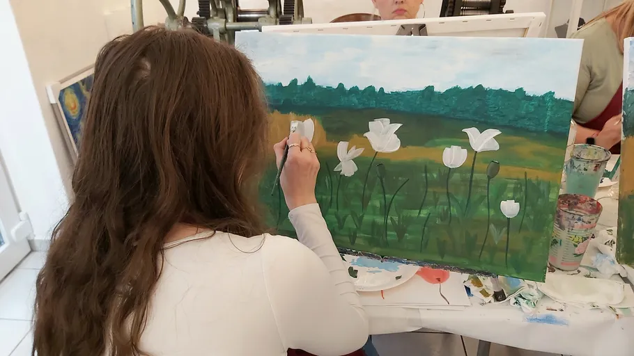 Frau malt Blumen im Kunststudio.