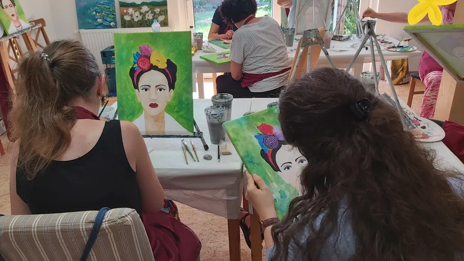 Women painting portraits in an art class.
