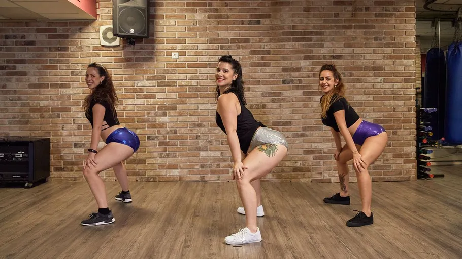 Drei Frauen tanzen in einem Fitnessstudio.