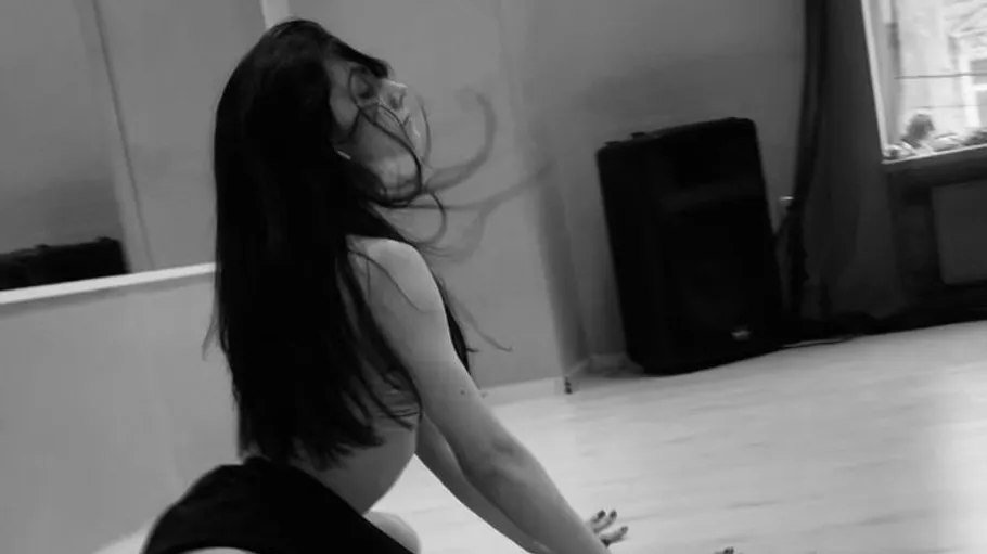 Frau tanzt im Studio, Haare wehen.