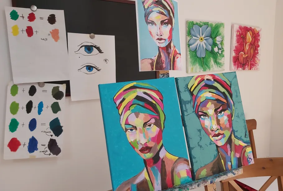 Colorful portraits on easel in art studio.