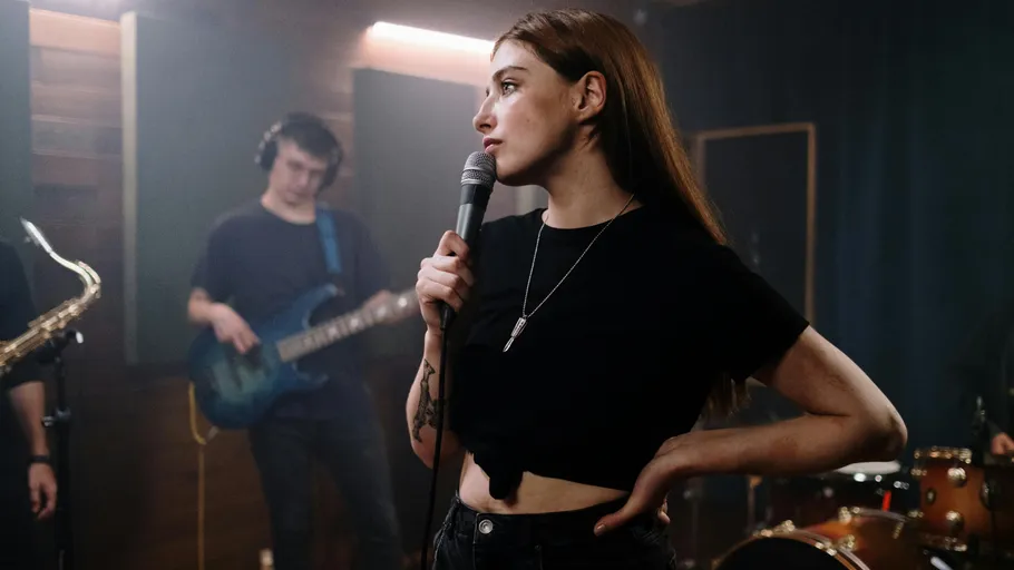 Woman singing into microphone, band playing behind.