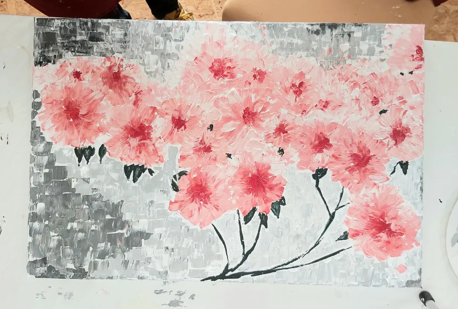 Pink flowers painted on a canvas.