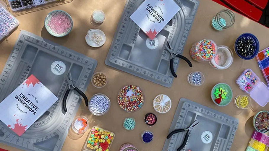 Beading workshop setup with tools and supplies.