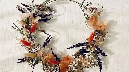Floral wreath hanging on a white wall.