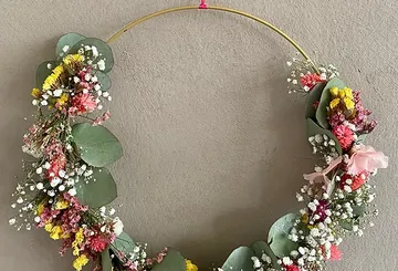 Floral wreath with colorful flowers on wall.