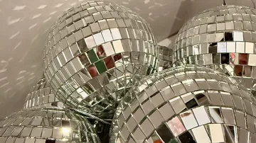 Verspiegelte Discokugeln reflektieren Licht im Cluster.