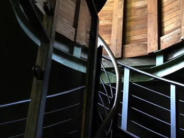 Bewegte Treppe in einem dunklen, holzvertäfelten Raum.
