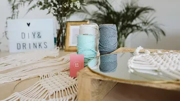 Craft supplies and sign on a table.