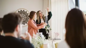 Frauen basteln in gemütlichem Raum.