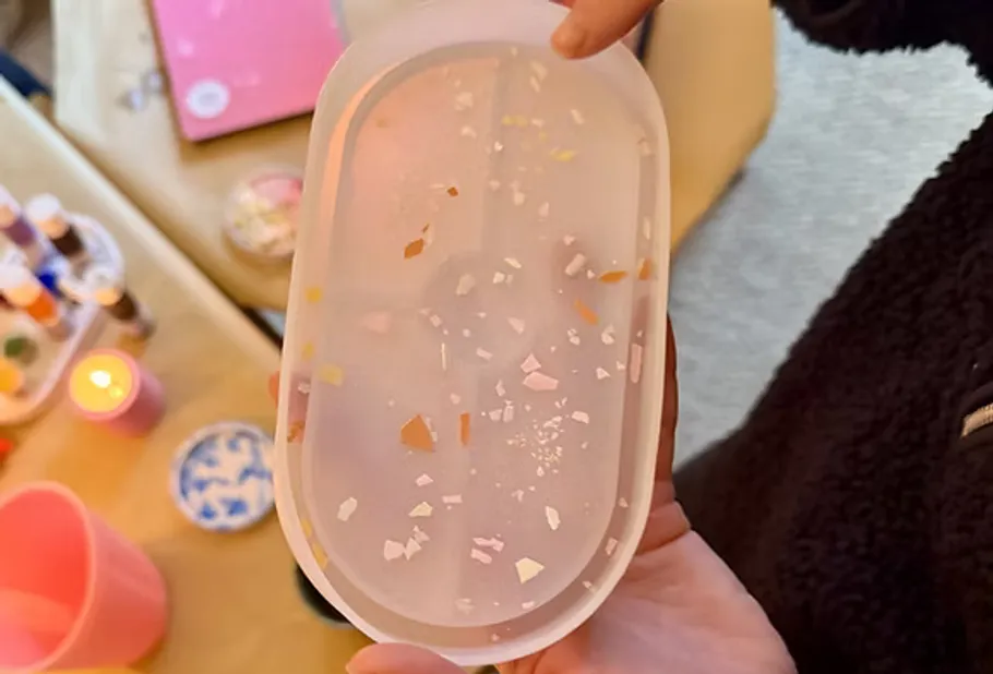 Hand holding translucent mold with speckles.