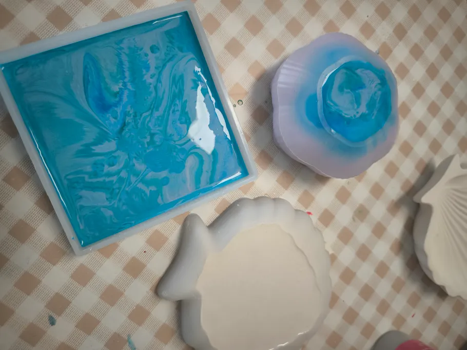 Colored resin molds on a checkered table.