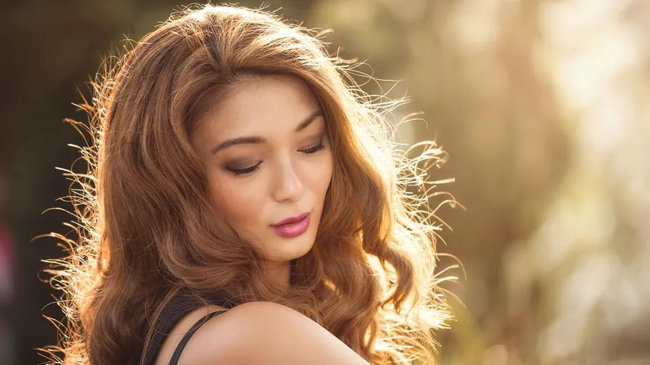 Woman with long hair in sunlight outdoors.