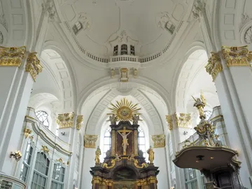 Grosser Kirchenraum mit goldenen Verzierungen und Altar.