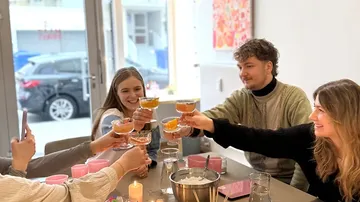 Menschen stoßen mit Getränken in einem Café an.