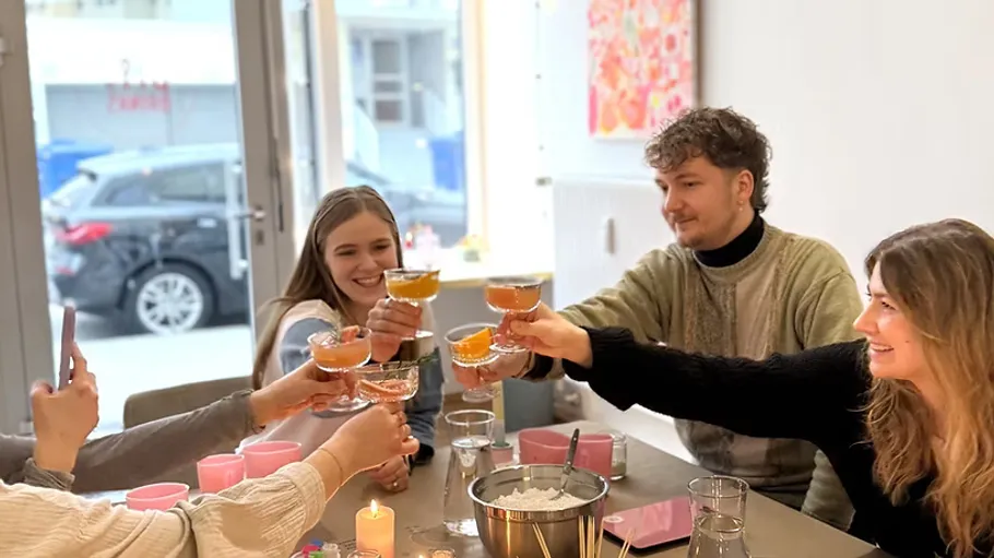 People toasting with drinks in a cafe.