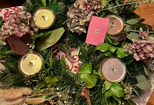 Adventskranz mit Kerzen und getrockneten Blumen.