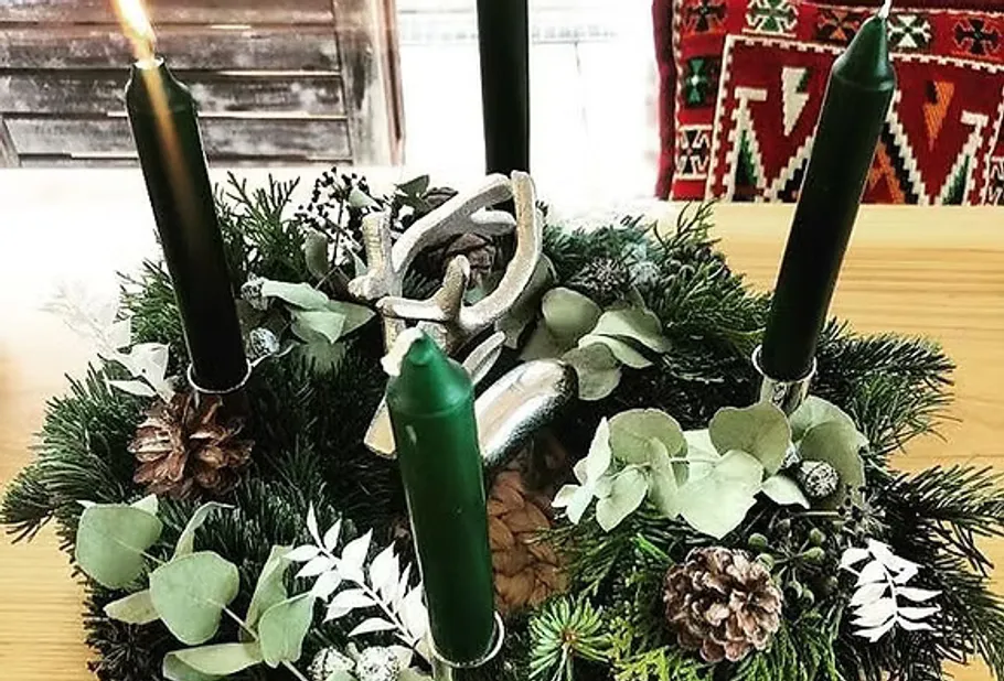 Grüne Kerzen auf einem festlichen Adventskranz.