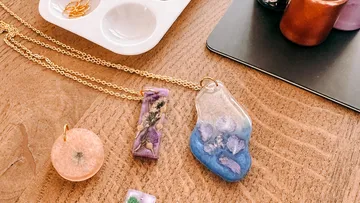 Bunte Harzschmuckstücke auf Holztisch.