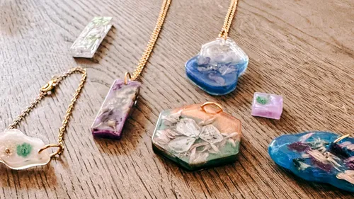 Colorful resin jewelry on wooden surface.