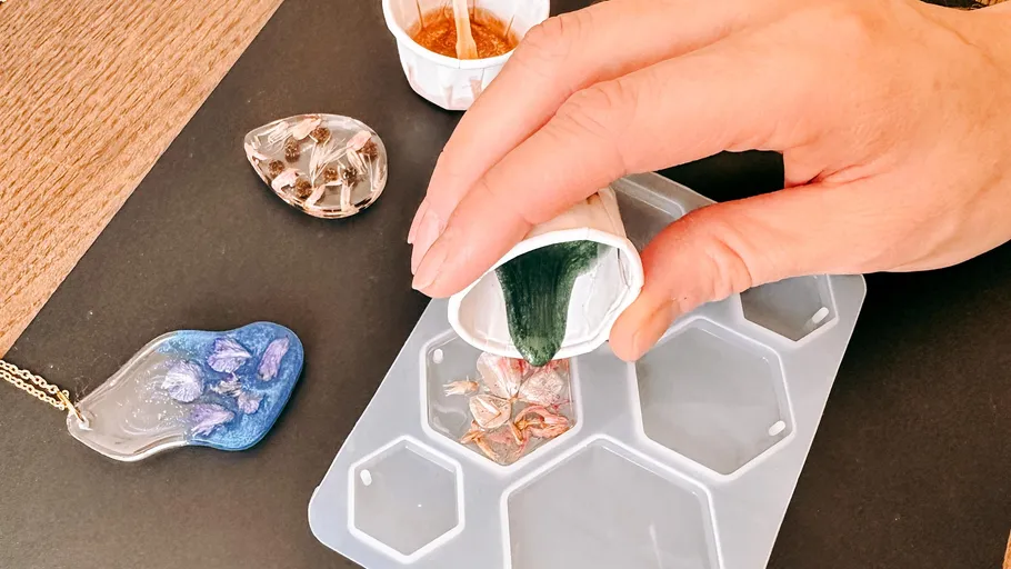 Hand pouring resin into hexagonal mold.