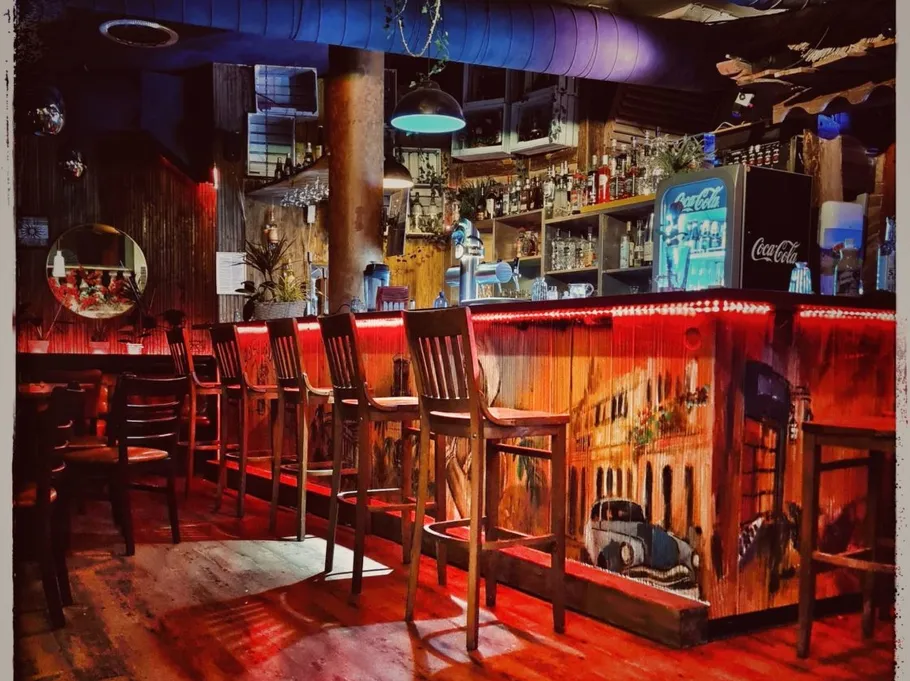 Leere Bar mit bunter Beleuchtung und Wandbild.
