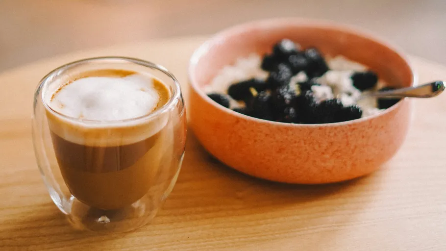 Kaffee und Beeren-Haferbrei auf Holztisch.