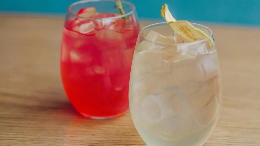Zwei Cocktails auf einem Holztisch.