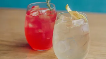 Two colorful drinks on wooden table.