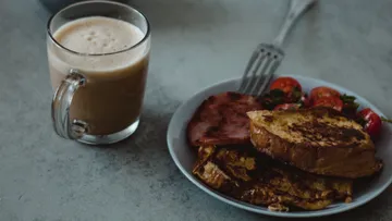 Breakfast plate with French toast, coffee nearby.