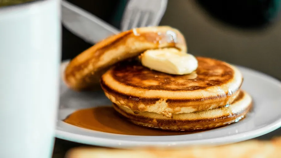 Pfannkuchen mit Butter und Sirup auf Teller.